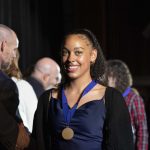 a student smiling at the camera wearing a medal