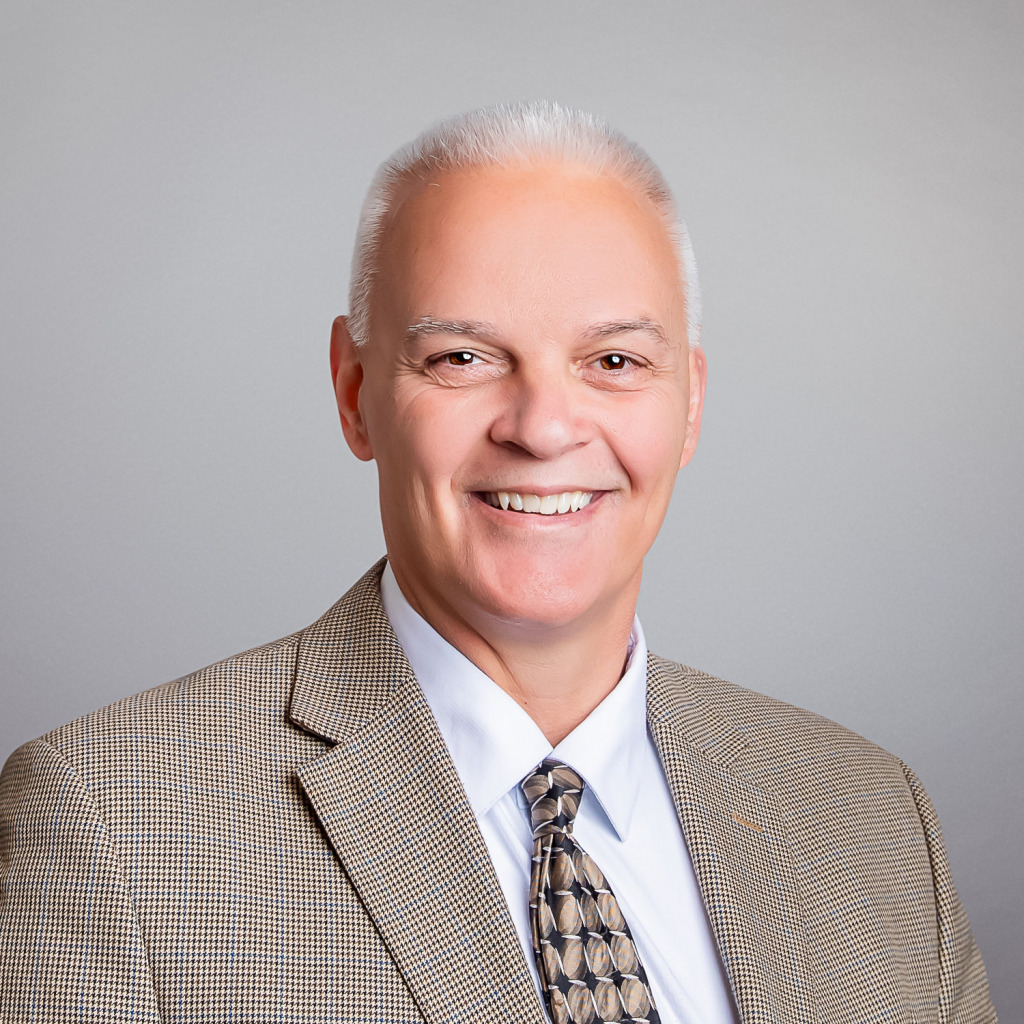 headshot of a man in a suit and tie
